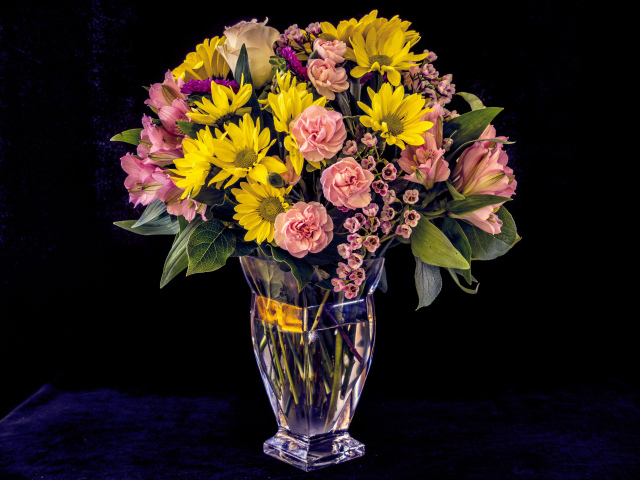 Букет красивых разноцветных цветов в вазе на черном фоне
