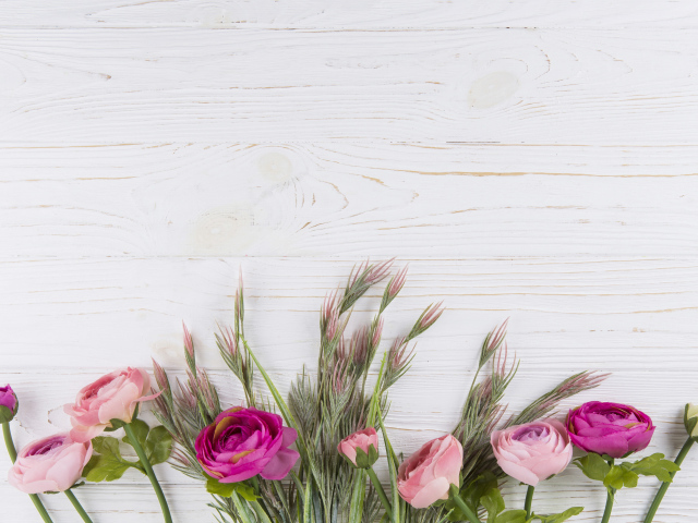 Букет разноцветных лютиков на белом столе