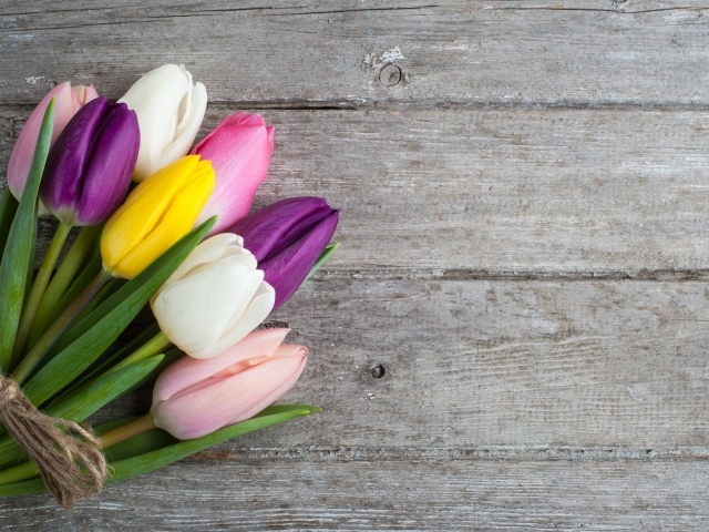 Букет разноцветных тюльпанов на деревянном столе
