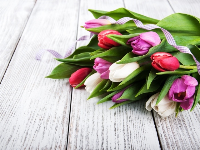 Букет свежих разноцветных тюльпанов на деревянном столе