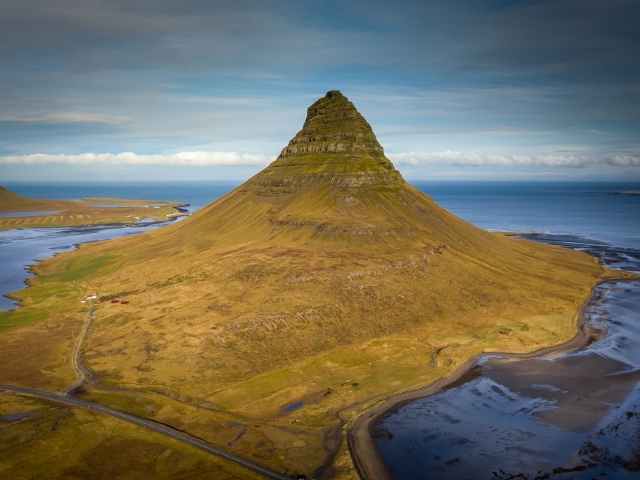 Зеленая гора Киркьюфетль под голубым небом, Исландия