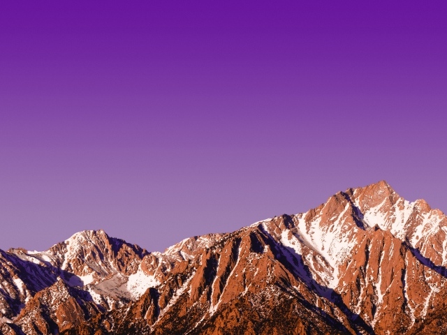 Вершины заснеженных гор на фоне сиреневого заката