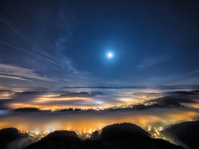 Вид с горы на покрытый туманом ночной город 