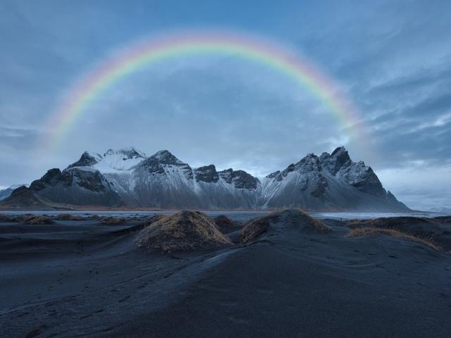 Радуга в небе над высокими горами