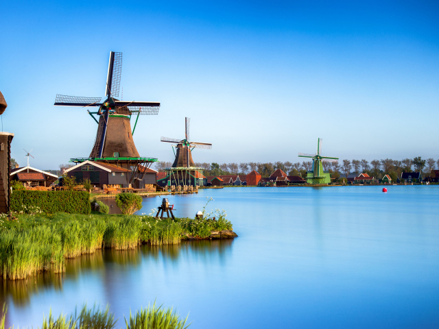 Мельницы  на берегу озера под голубым небом 