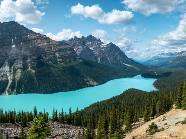 Тень от белых облаков на горном массиве у голубого озера