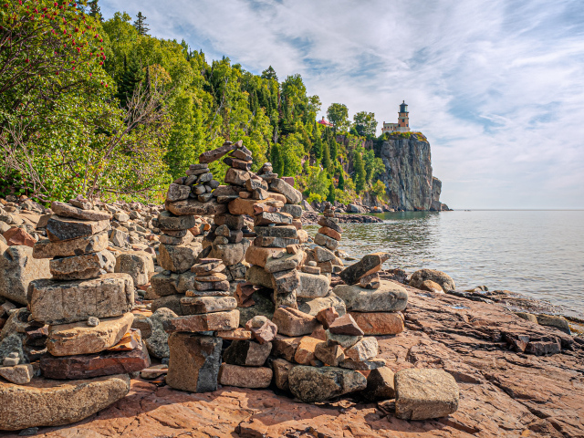 Много камней на берегу моря под красивым небом 