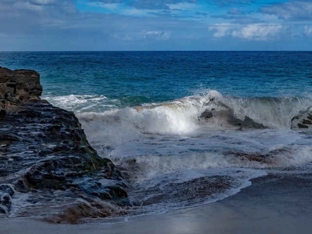 Бушующие белые волны в море у скал 