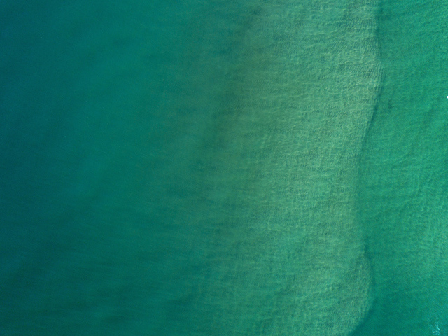 Вид сверху на спокойную голубую гладь океана