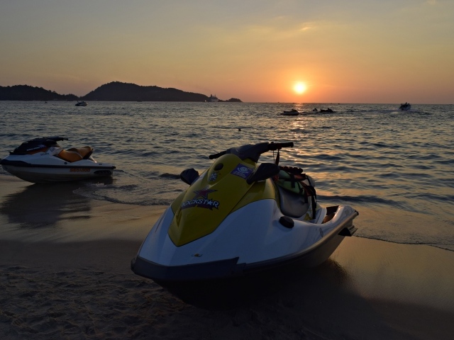 Водный скутер на мокром песке у моря на закате