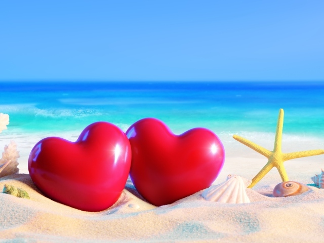  Два красных сердца на пляже с морскими звездами летом