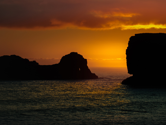 Скалы в море на закате солнца  