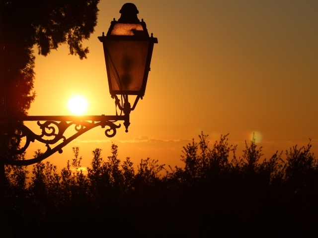 Фонарь на дома на закате солнца