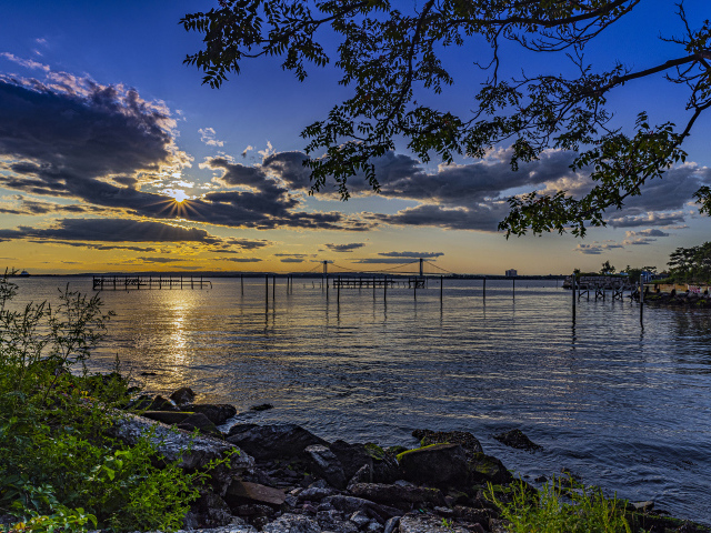Солнце садится за тучи на горизонте в море