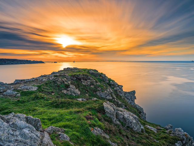 Вид со скалы на красивый закат в небе над спокойным морем 