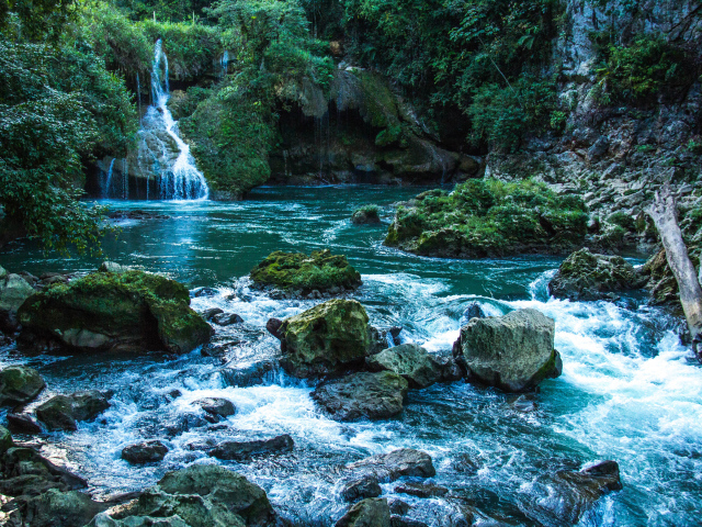 Голубая вода в водопаде стекает по камням 