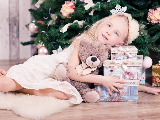 Красивая голубоглазая девочка с подарками у елки