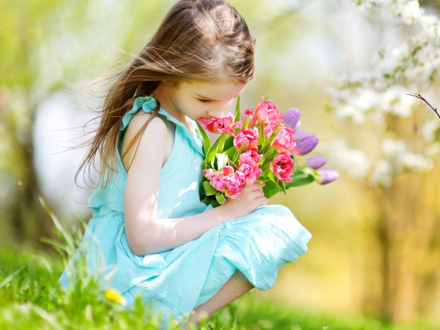 Красивая девочка в голубом платье с букетом тюльпанов