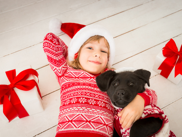 Милая девочка в новогоднем костюме на полу с собакой 