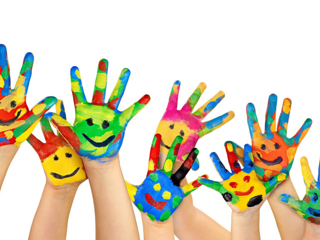 Смайлики нарисованы красками на руках детей на белом фоне