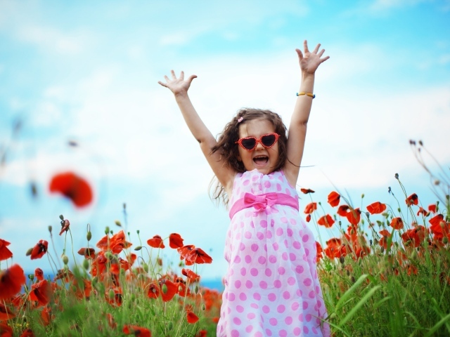 Счастливая маленькая девочка в платье на поле с маками