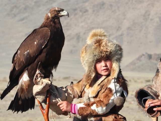 Маленький ребенок на охоте с хищным орлом