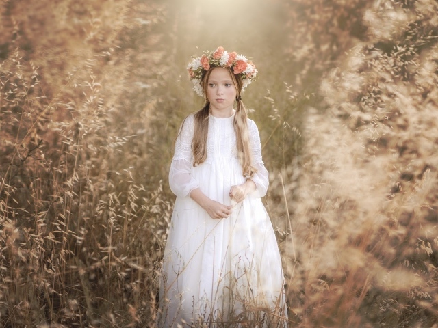 Маленькая девочка в белом платье с венком на голове 