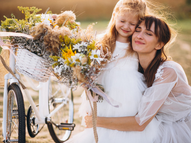 Маленькая девочка с мамой у велосипеда