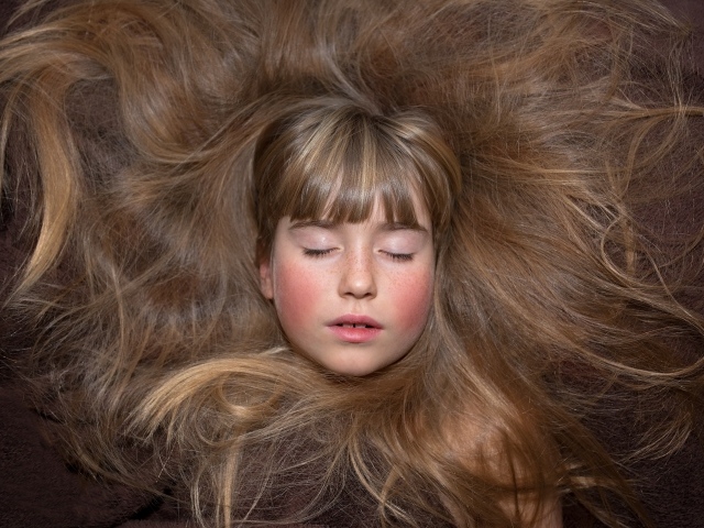 Маленькая спящая девочка с длинными волосами