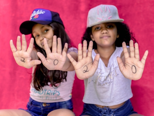 Две маленькие девочка с цифрами на ладонях 