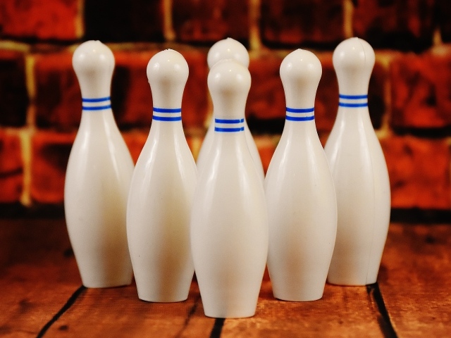 Белые кегли стоят у стены 