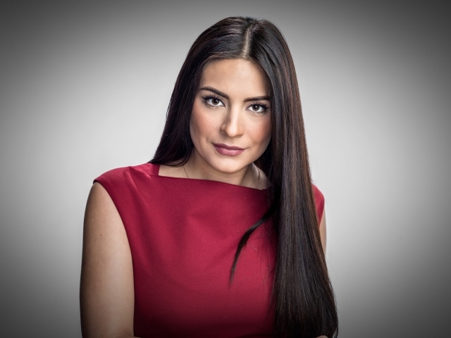 Актриса Ана Бренда Контрерас в красном платье на сером фоне