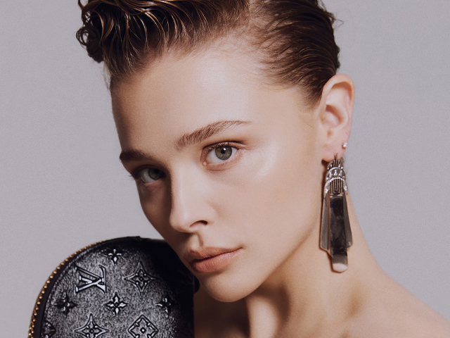 Актриса Хлоя Грейс Морец лицо крупным планом на сером фоне