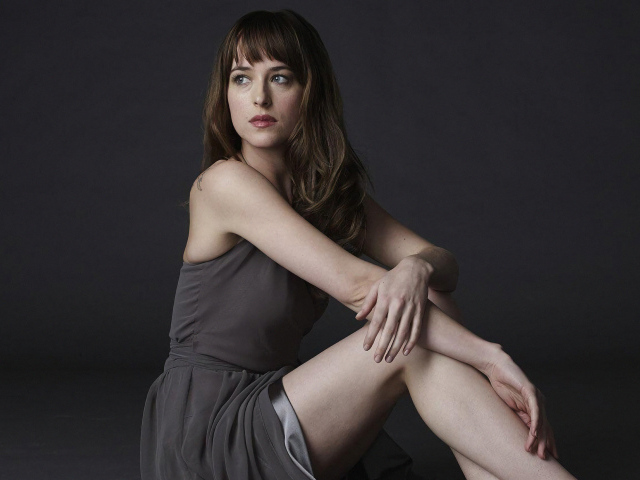 Актриса Дакота Джонсон в платье на сером фоне