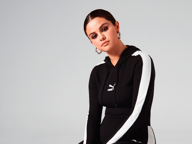 Актриса, модель Селена Гомес в спортивном костюме на сером фоне