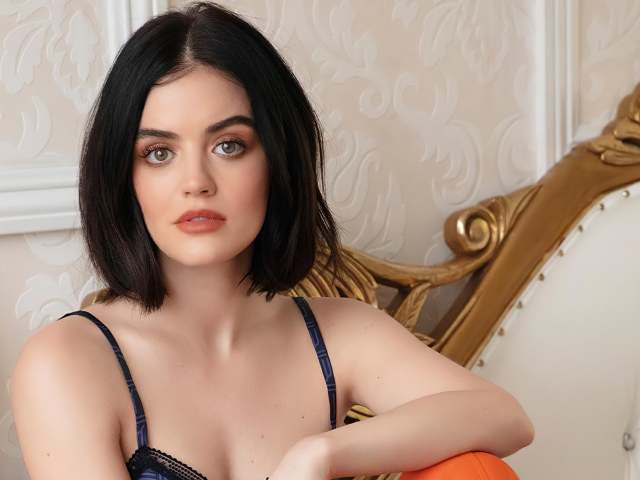 Красивая девушка, актриса Люси Хейл сидит на диване