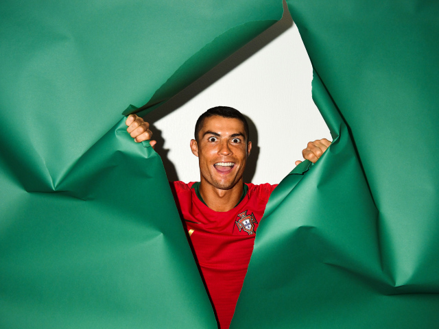 Смешное лицо футболиста Криштиану Роналду на зеленом фоне