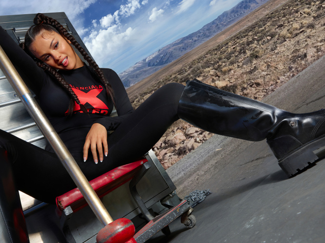 Смешная девушка, певица и актриса Селена Гомес сидит на стуле