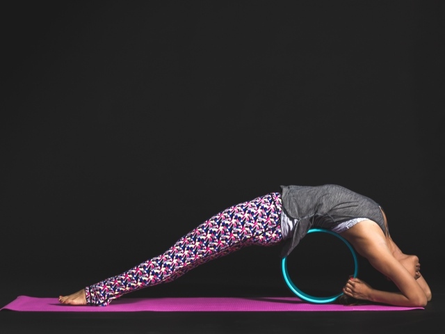 Девушка делает упражнения для спины на черном фоне