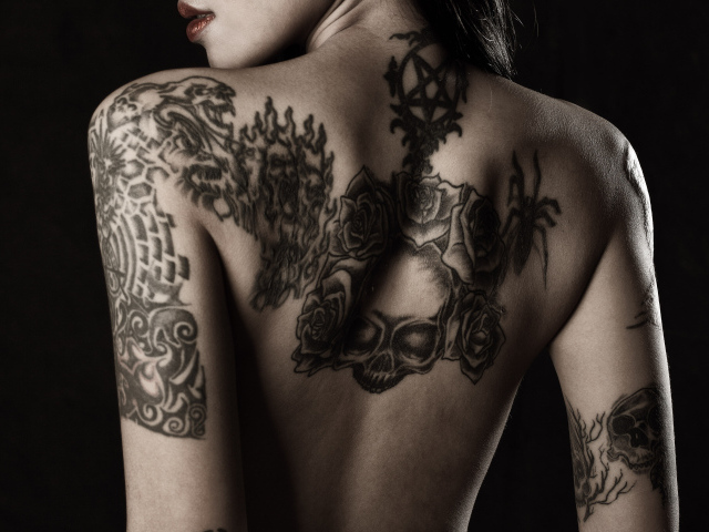 Девушка с татуировками на руках и спине