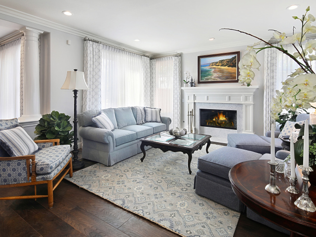 Большая гостиная комната с камином и живыми цветами