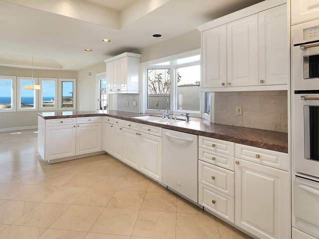 Большая белая кухня с окнами 