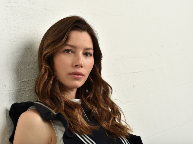 Грустная актриса Джессика Бил сидит у стены