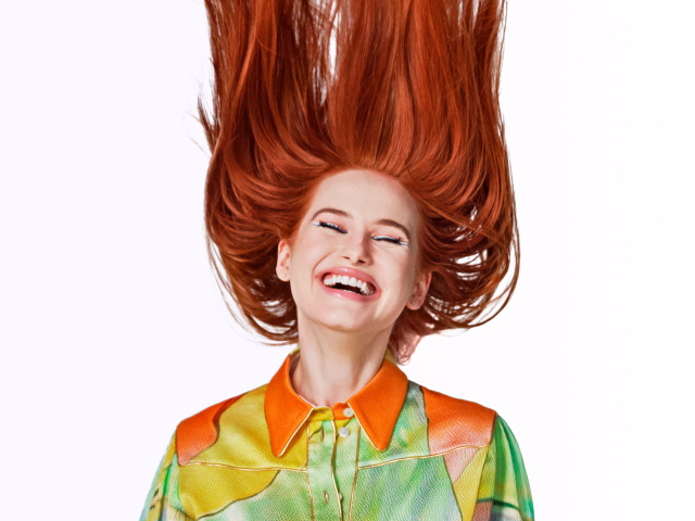 Улыбающаяся актриса Мэделин Петш с рыжими волосами на белом фоне