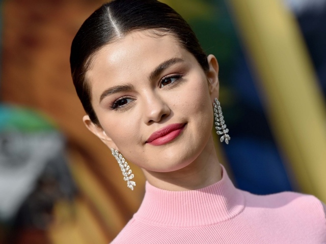 Улыбающаяся актриса и певица Селена Гомез с сережками в ушах