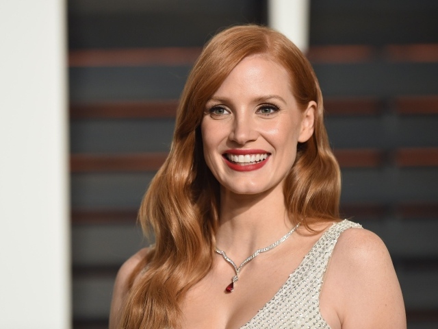 Улыбающаяся женщина, актриса Джессика Честейн с украшением на шее