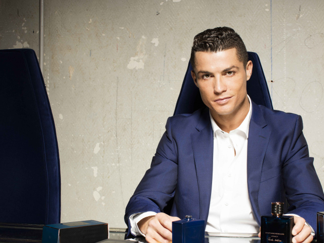 Стильный мужчина, футболист Криштиану Роналду с духами за столом