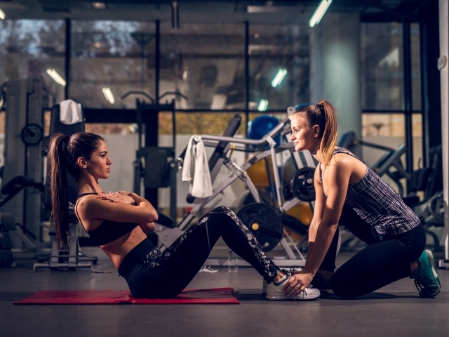 Две девушки занимаются в спортзале 