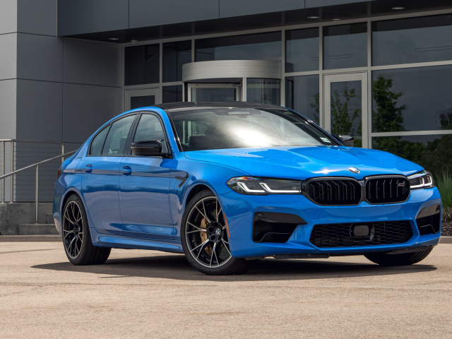 Голубой автомобиль BMW M5, 2021 года у здания