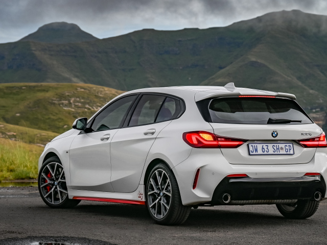 Белый автомобиль BMW 128ti 2021 года вид сзади на фоне гор